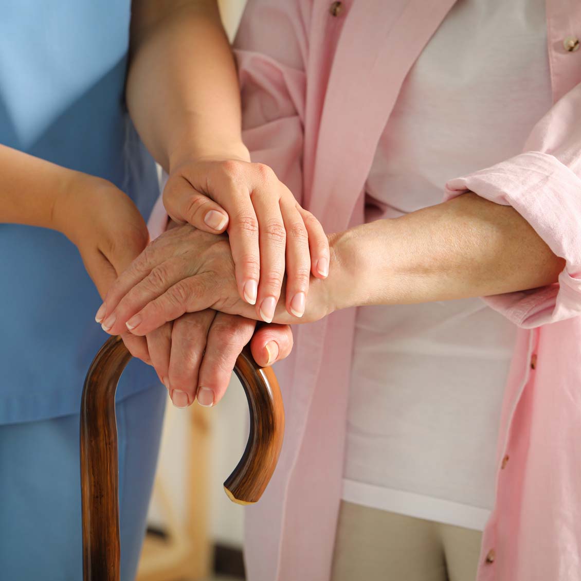 Elderly woman with walking cane and female caregiver