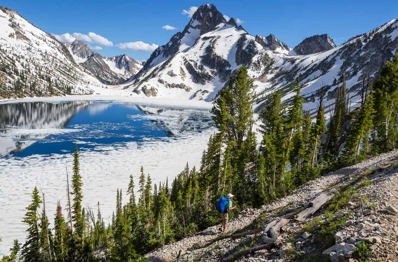 Hiking in Northern, Idaho in the winter time with wintery mountains and a snow covered lake