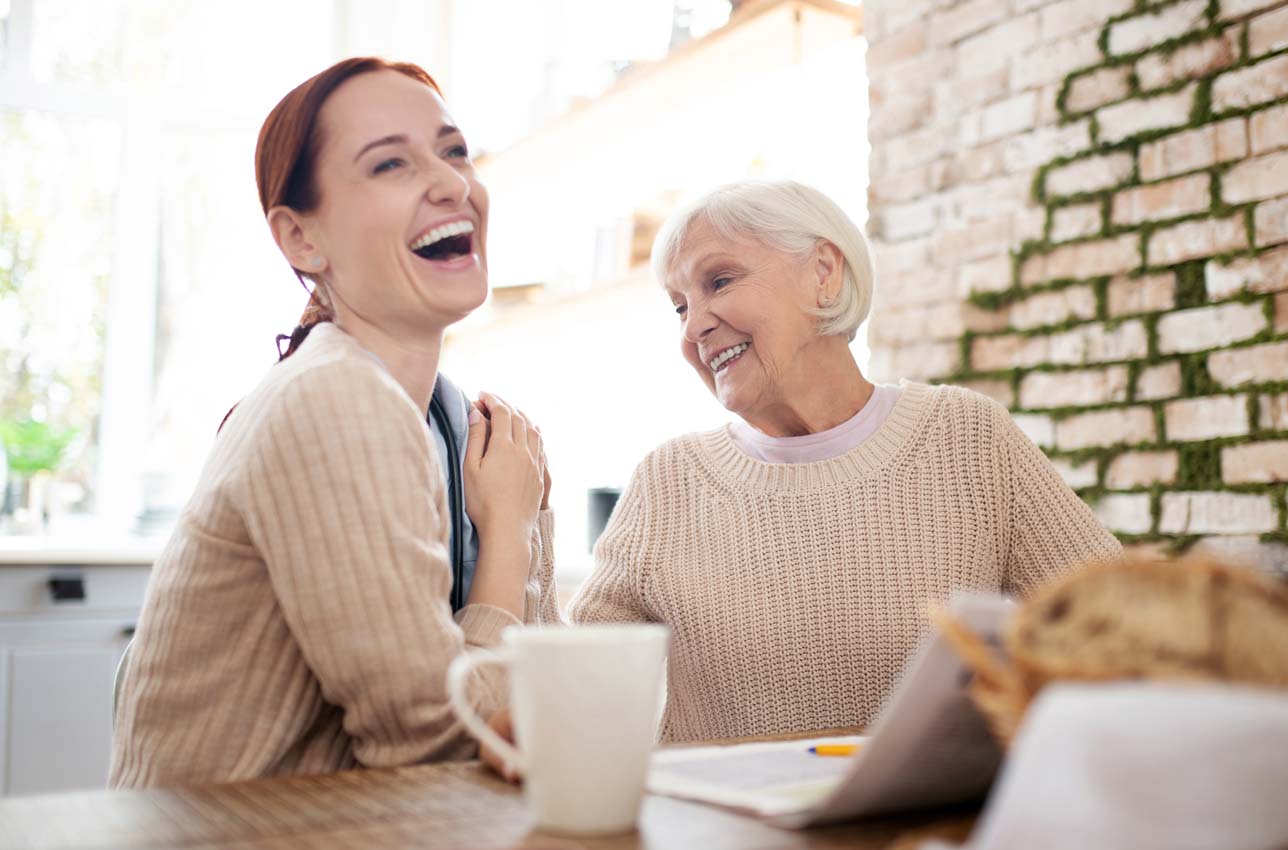Two Women Laughing Together Indoors in Home Setting