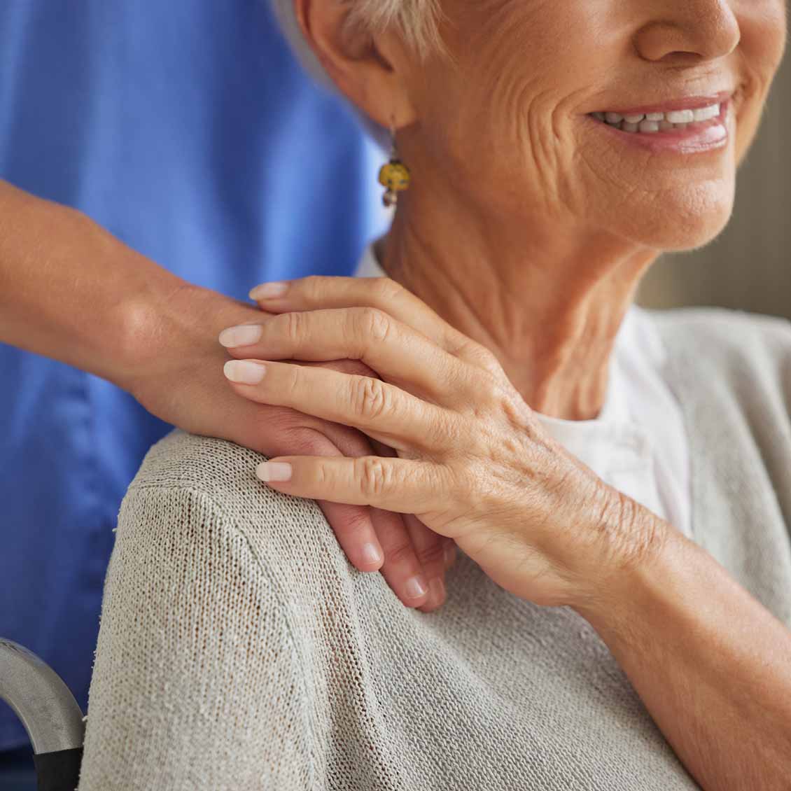 Closeup of an unrecognizable personal care assistant offering her hand to an elder lady sitting