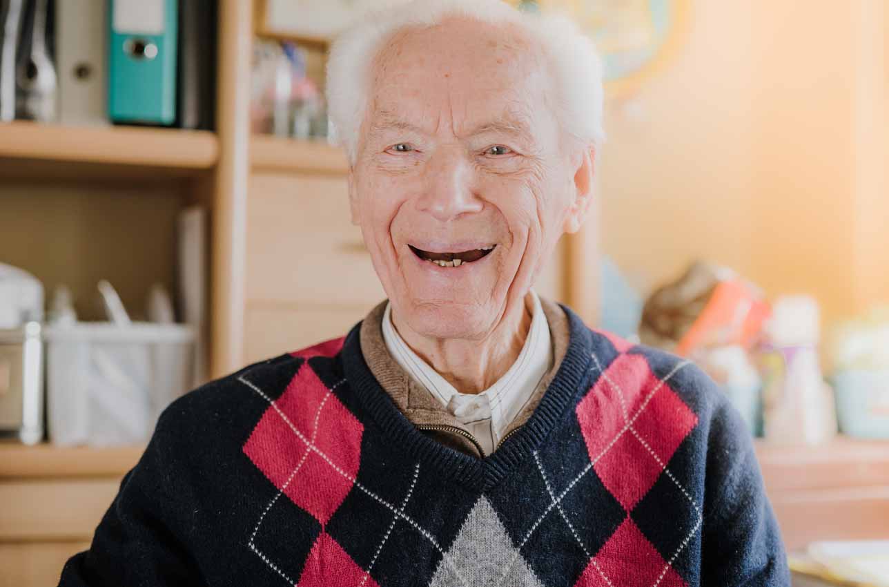 Smiling senior man indoors wearing argyle sweater