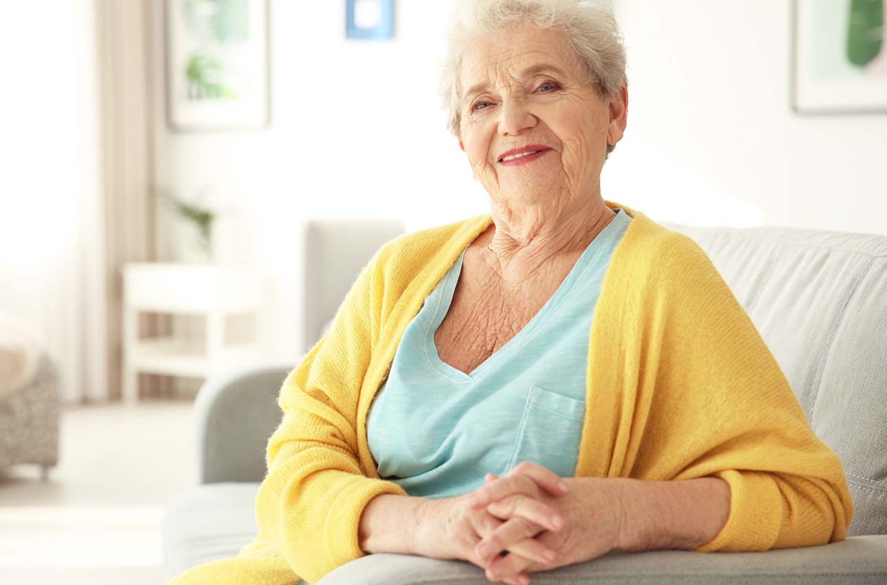 services-senior-care-hero Elderly woman sitting on couch in living room
